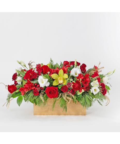 The Crimson Jubilee arrangement  is a stunning holiday centerpiece that combines rich, vibrant hues and festive elegance in a luxurious gold ceramic container. 